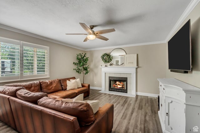 6063 S Kamas Dr W, Taylorsville, UT 84129 - living room featuring light wood-style flooring, a ceiling fan, a tile fireplace, and ornamental molding