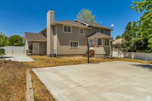 6063 S Kamas Dr W, Taylorsville, UT 84129 - back of property with a chimney, stucco siding, and a patio