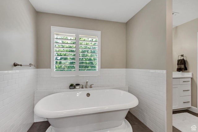 6063 S Kamas Dr W, Taylorsville, UT 84129 - bathroom featuring tile walls, a freestanding bath, tile patterned floors, and a wainscoted wall
