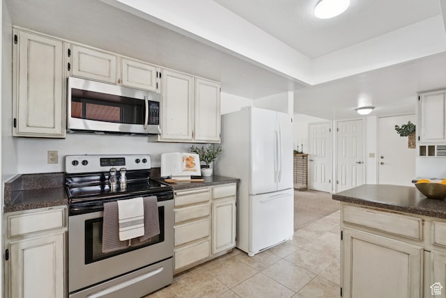 1074 E Spring Ridge Dr, Sandy, UT 84094 - kitchen featuring appliances with stainless steel finishes, dark countertops, and light tile patterned flooring