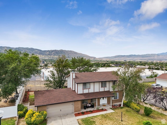 1074 E Spring Ridge Dr, Sandy, UT 84094 - view of front of home featuring a shingled roof, a mountain view, concrete driveway, brick siding, and an attached garage