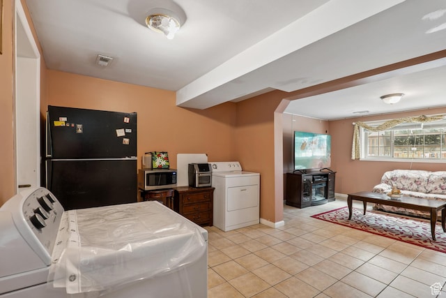 601 E Hilo St S, Sandy, UT 84070 - kitchen with washer / dryer, freestanding refrigerator, stainless steel microwave, and light tile patterned floors