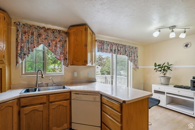 601 E Hilo St S, Sandy, UT 84070 - kitchen featuring white dishwasher, a peninsula, light countertops, a textured ceiling, and brown cabinets