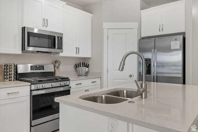 1210 N Mistico Aly, Washington, UT 84780 - kitchen with stainless steel appliances, white cabinets, a kitchen island with sink, and light stone counters