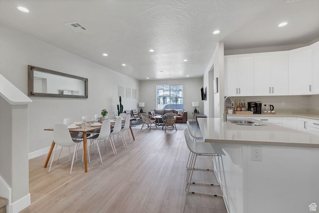 1210 N Mistico Aly, Washington, UT 84780 - kitchen featuring light wood-style flooring, recessed lighting, white cabinetry, light countertops, and open floor plan