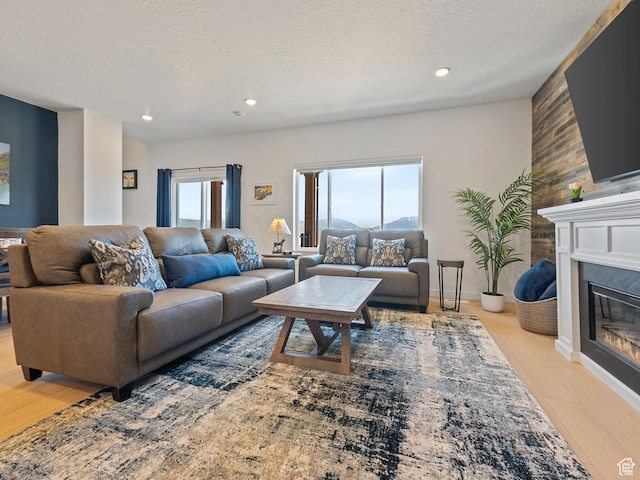 2309 N Wildwood Ln, Heber City, UT 84032 - living room with a glass covered fireplace, light wood finished floors, healthy amount of natural light, a textured ceiling, and recessed lighting