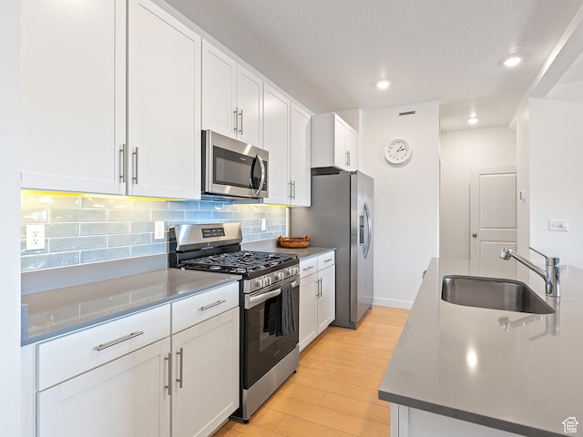 2309 N Wildwood Ln, Heber City, UT 84032 - kitchen featuring stainless steel appliances, light wood-type flooring, tasteful backsplash, white cabinetry, and recessed lighting