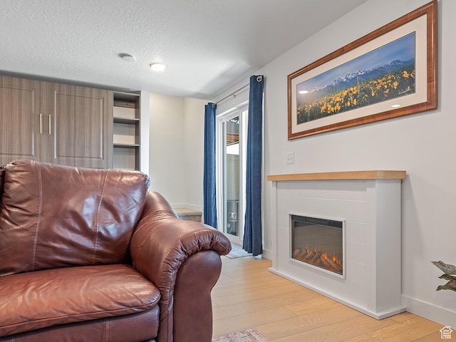 2309 N Wildwood Ln, Heber City, UT 84032 - living room featuring light wood-style floors, a textured ceiling, and a glass covered fireplace