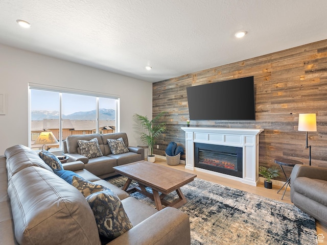 2309 N Wildwood Ln, Heber City, UT 84032 - living room featuring wood walls, an accent wall, recessed lighting, a glass covered fireplace, and a textured ceiling