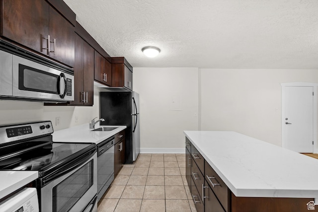 555 E 100 S Unit 303, Salt Lake City, UT 84102 - kitchen featuring appliances with stainless steel finishes, a center island, light countertops, dark brown cabinets, and a textured ceiling