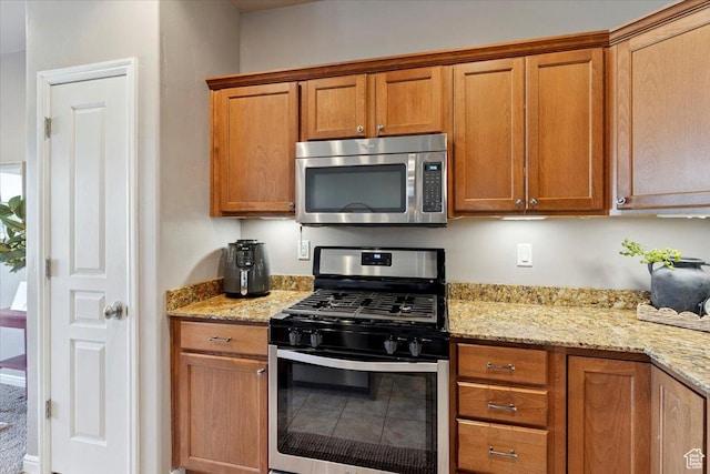 164 S 2875 W, West Point, UT 84015 - kitchen featuring stainless steel appliances, brown cabinets, and light stone counters