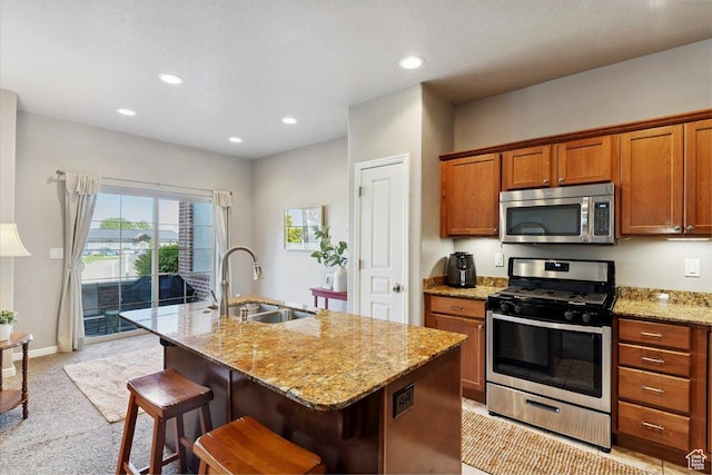 164 S 2875 W, West Point, UT 84015 - kitchen featuring stainless steel appliances, brown cabinetry, light stone countertops, light carpet, and a center island with sink