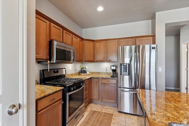 164 S 2875 W, West Point, UT 84015 - kitchen featuring appliances with stainless steel finishes, brown cabinetry, light stone counters, light tile patterned floors, and recessed lighting