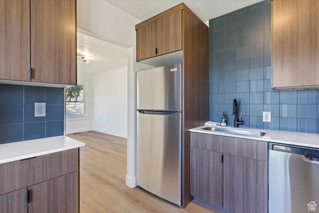 178 Country Club Dr, South Ogden, UT 84405 - kitchen featuring stainless steel appliances, light wood-type flooring, light countertops, backsplash, and a textured ceiling