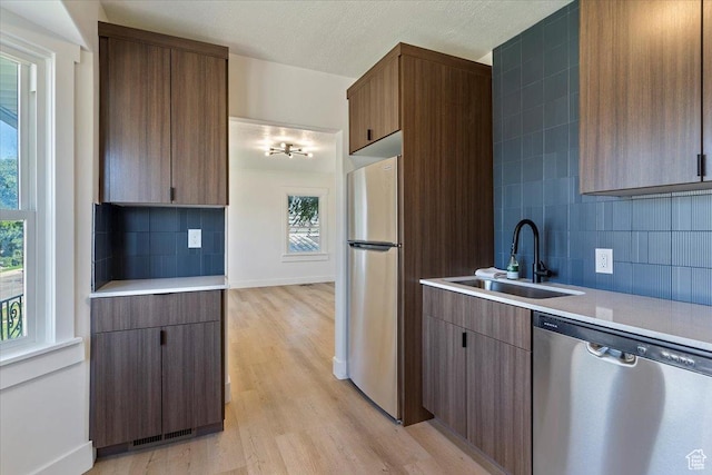 178 Country Club Dr, South Ogden, UT 84405 - kitchen with stainless steel appliances, light countertops, light wood-type flooring, decorative backsplash, and a textured ceiling