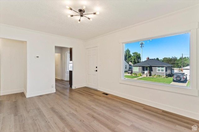 178 Country Club Dr, South Ogden, UT 84405 - empty room featuring light wood-style floors, crown molding, a chandelier, and a textured ceiling