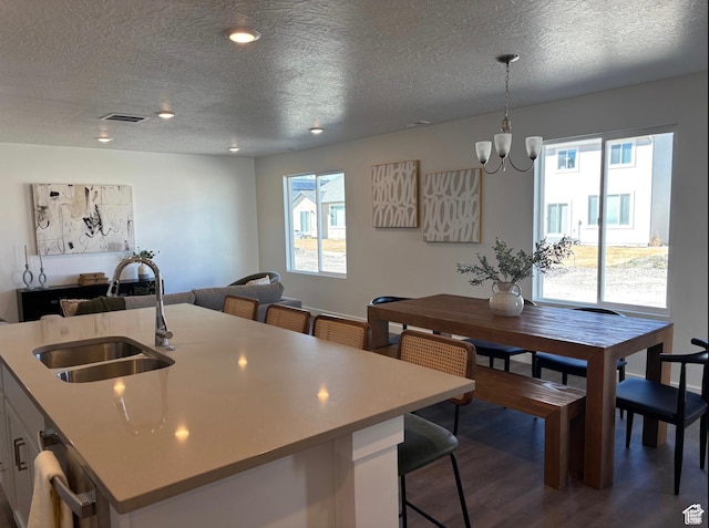 1536 E Pheasant Rd Unit 214, Eagle Mountain, UT 84005 - kitchen featuring dark wood-type flooring, a textured ceiling, light countertops, open floor plan, and decorative light fixtures