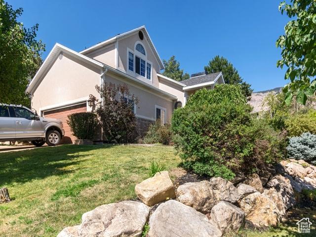 466 E 3460 N, North Ogden, UT 84414 - view of home's exterior featuring an attached garage, stucco siding, and a lawn