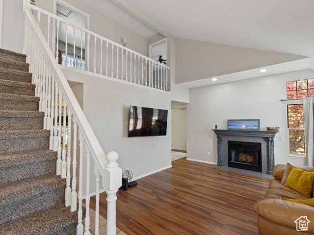 466 E 3460 N, North Ogden, UT 84414 - living area featuring wood finished floors, stairway, a tiled fireplace, high vaulted ceiling, and recessed lighting