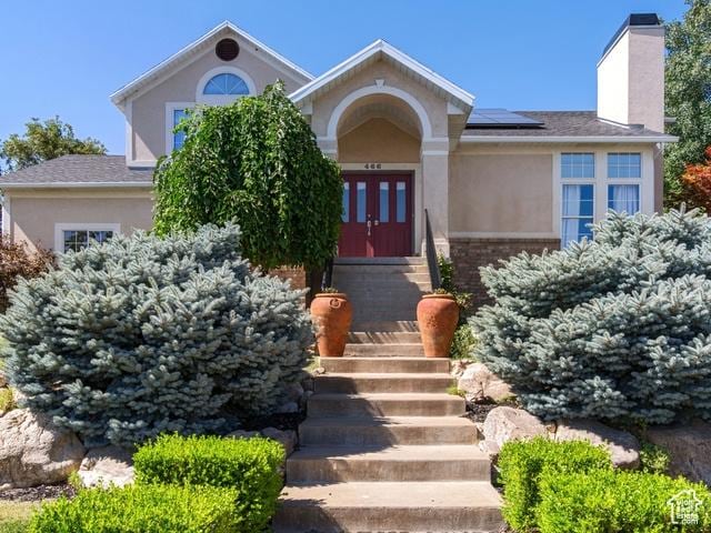466 E 3460 N, North Ogden, UT 84414 - view of front of home with a chimney, stucco siding, solar panels, and french doors