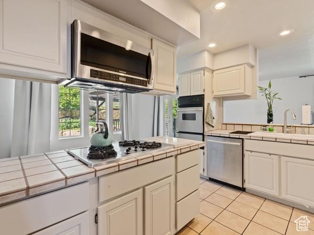 466 E 3460 N, North Ogden, UT 84414 - kitchen featuring tile countertops, appliances with stainless steel finishes, light tile patterned floors, and recessed lighting