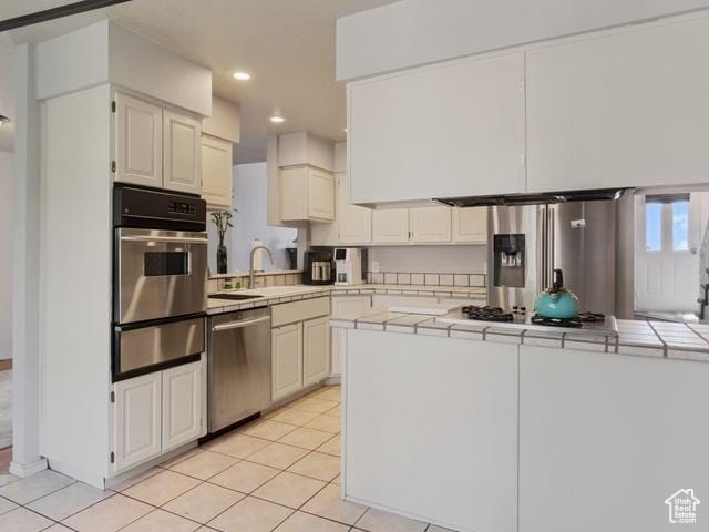 466 E 3460 N, North Ogden, UT 84414 - kitchen with stainless steel appliances, a warming drawer, tile countertops, light tile patterned floors, and recessed lighting