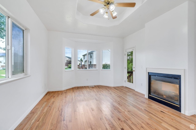 1430 S Heather Ln, Syracuse, UT 84075 - unfurnished living room with plenty of natural light, light wood-style flooring, a glass covered fireplace, and a ceiling fan