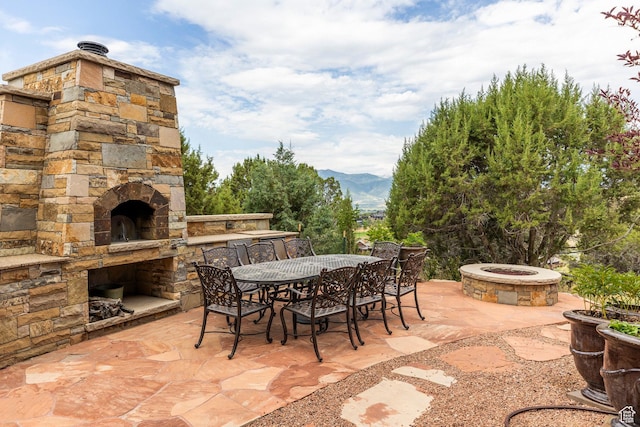 223 N Ibapah Peak Dr, Heber City, UT 84032 - view of patio / terrace with an outdoor stone fireplace, a mountain view, and outdoor dining area
