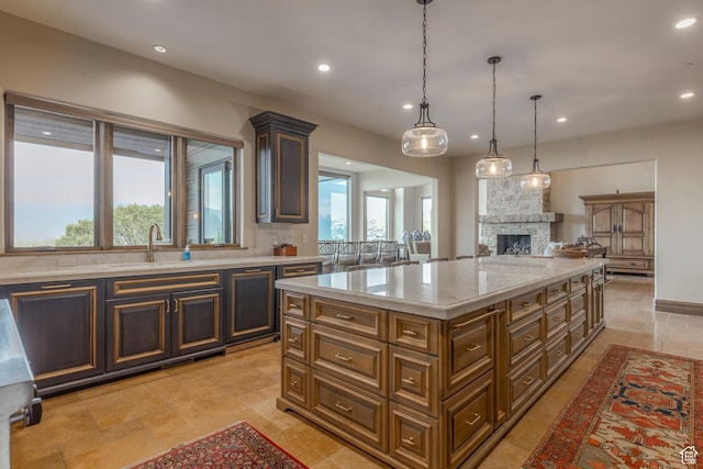 223 N Ibapah Peak Dr, Heber City, UT 84032 - kitchen with a fireplace, recessed lighting, light stone countertops, pendant lighting, and a kitchen island