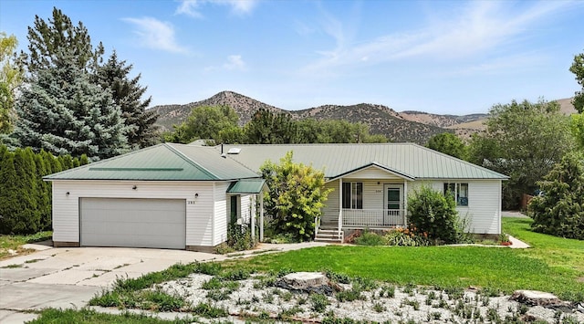 390 N 400 W, Malad City, ID 83252 - ranch-style house with a porch, a mountain view, driveway, a front lawn, and an attached garage