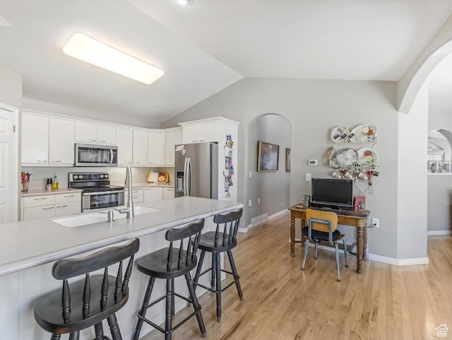 2287 N 470 E, Provo, UT 84604 - kitchen featuring stainless steel appliances, arched walkways, vaulted ceiling, a breakfast bar area, and light countertops