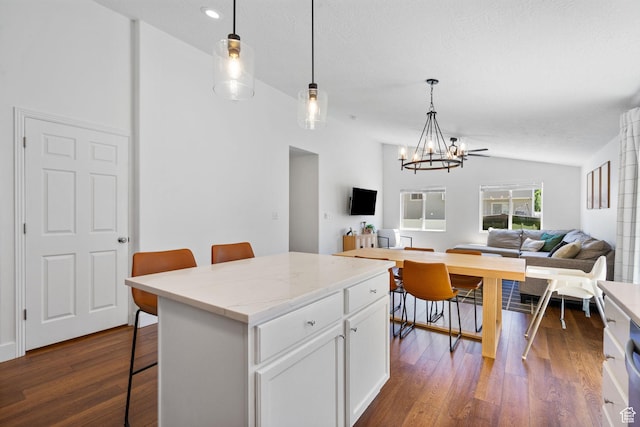 2344 E 1120 S, Spanish Fork, UT 84660 - kitchen with vaulted ceiling, a chandelier, dark wood-style floors, a breakfast bar, and white cabinetry