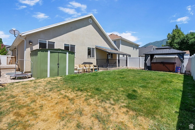 2344 E 1120 S, Spanish Fork, UT 84660 - back of house with a storage unit, a fenced backyard, a hot tub, and stucco siding