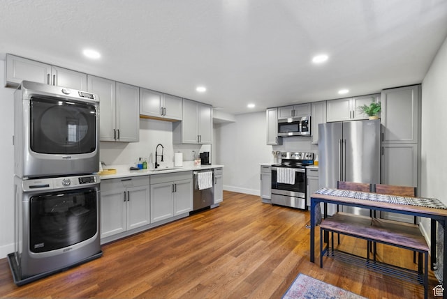 2344 E 1120 S, Spanish Fork, UT 84660 - kitchen with appliances with stainless steel finishes, estacked washer and dryer, gray cabinets, light countertops, and wood finished floors