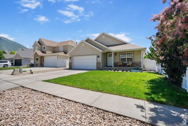 2344 E 1120 S, Spanish Fork, UT 84660 - view of front facade with concrete driveway, stone siding, covered porch, a garage, and stucco siding