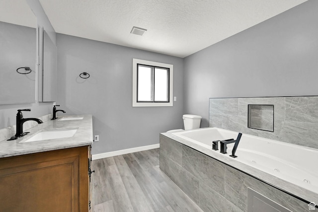 5577 W 4000 S, Hooper, UT 84315 - bathroom featuring a whirlpool tub, double vanity, wood finished floors, and a textured ceiling