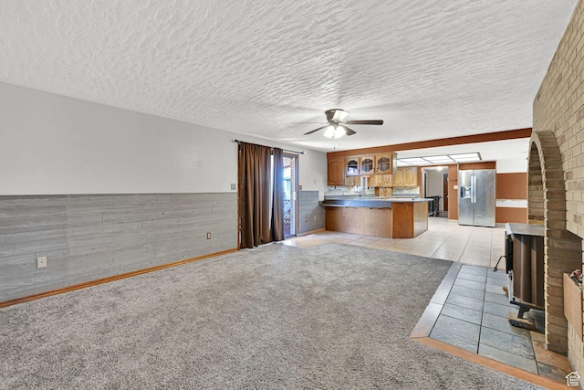 5577 W 4000 S, Hooper, UT 84315 - kitchen featuring stainless steel fridge with ice dispenser, a peninsula, brown cabinets, ceiling fan, and glass insert cabinets