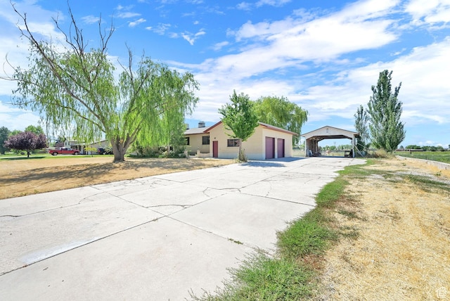 5577 W 4000 S, Hooper, UT 84315 - view of front of house with concrete driveway, a garage, a carport, and stucco siding