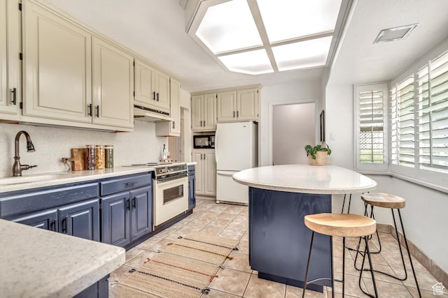 4269 S Vegas Way E, Holladay, UT 84124 - kitchen featuring white appliances, light countertops, a kitchen breakfast bar, blue cabinetry, and cream cabinets