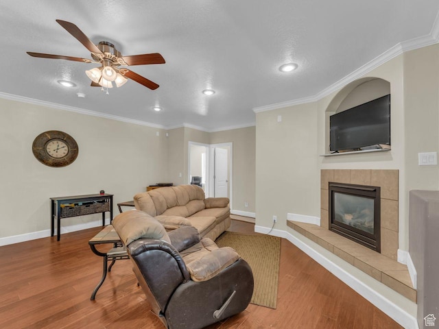 8503 S Spiral Jetty Cir W Unit 2083, West Jordan, UT 84081 - living room featuring wood finished floors, a tile fireplace, a ceiling fan, recessed lighting, and ornamental molding
