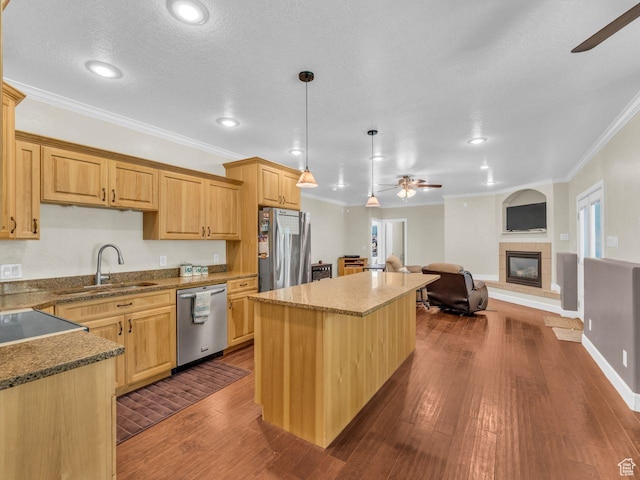 8503 S Spiral Jetty Cir W Unit 2083, West Jordan, UT 84081 - kitchen featuring ceiling fan, appliances with stainless steel finishes, crown molding, a center island, and a fireplace