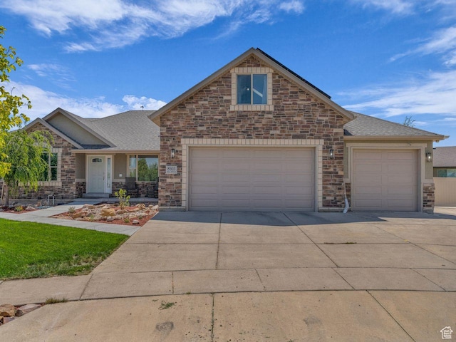 8503 S Spiral Jetty Cir W Unit 2083, West Jordan, UT 84081 - view of front of house with concrete driveway, stone siding, and an attached garage