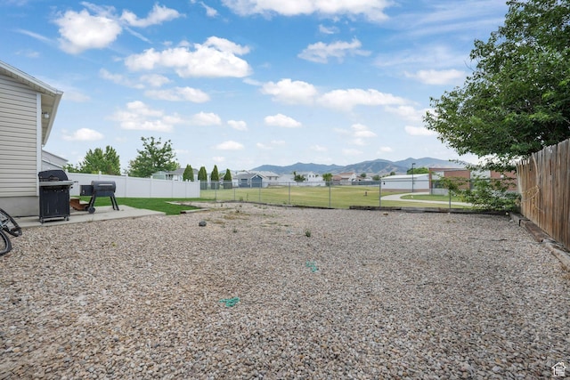 3142 S Sugar Bowl Ln, West Valley City, UT 84128 - fenced backyard with a mountain view and a patio area