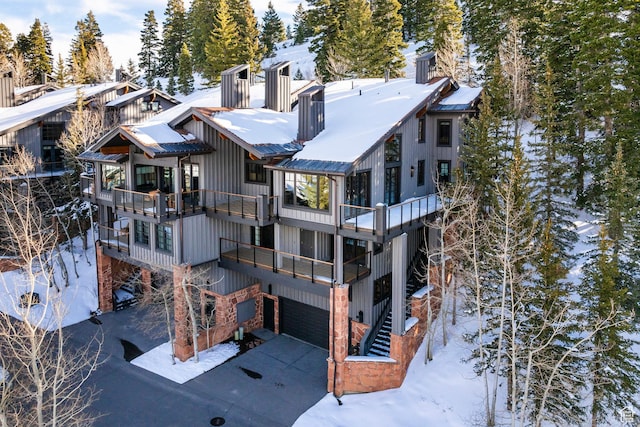 8200 Royal St Unit 43, Park City, UT 84060 - snow covered rear of property with a balcony, a garage, driveway, and a chimney