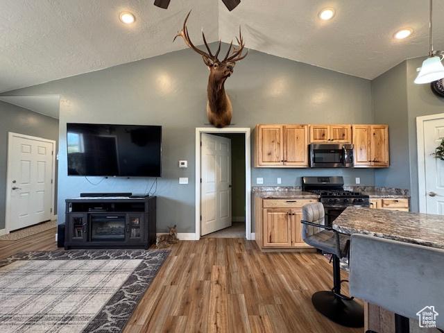 4058 E 5000 S, Vernal, UT 84078 - kitchen featuring stainless steel microwave, gas stove, high vaulted ceiling, wood finished floors, and open floor plan