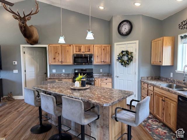 4058 E 5000 S, Vernal, UT 84078 - kitchen featuring black appliances, a kitchen breakfast bar, wood finished floors, a kitchen island, and recessed lighting