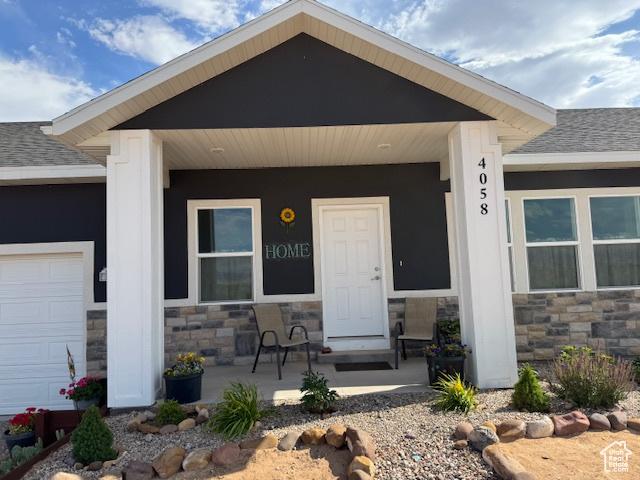 4058 E 5000 S, Vernal, UT 84078 - view of exterior entry with a porch, stone siding, and roof with shingles
