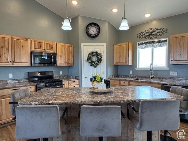 4058 E 5000 S, Vernal, UT 84078 - kitchen featuring stainless steel appliances, a breakfast bar area, vaulted ceiling, a kitchen island, and dark wood finished floors