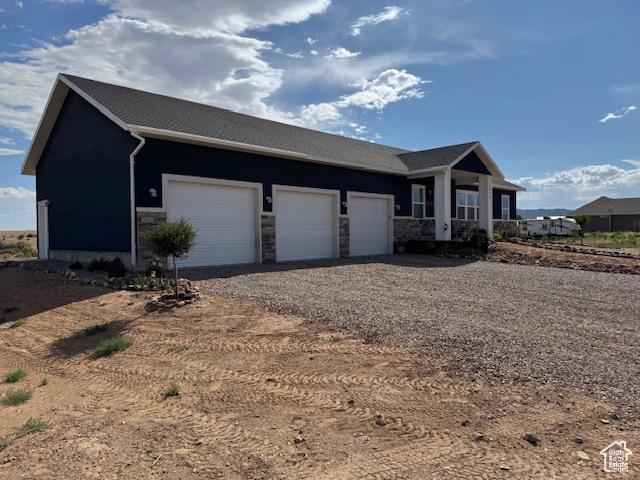 4058 E 5000 S, Vernal, UT 84078 - view of front facade with dirt driveway, stone siding, and a garage