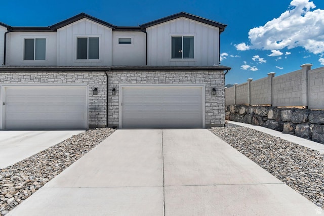 1162 N 550 W Unit 110, Tooele, UT 84074 - view of front of home with board and batten siding, an attached garage, driveway, and stone siding